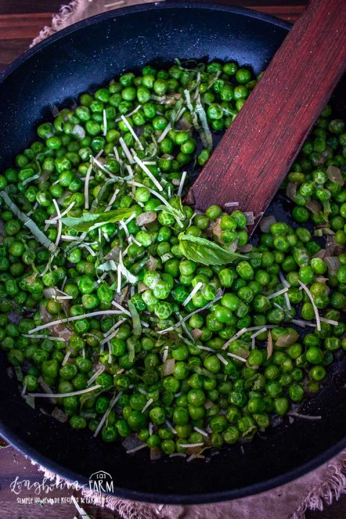 stirring the italian peas in the pan