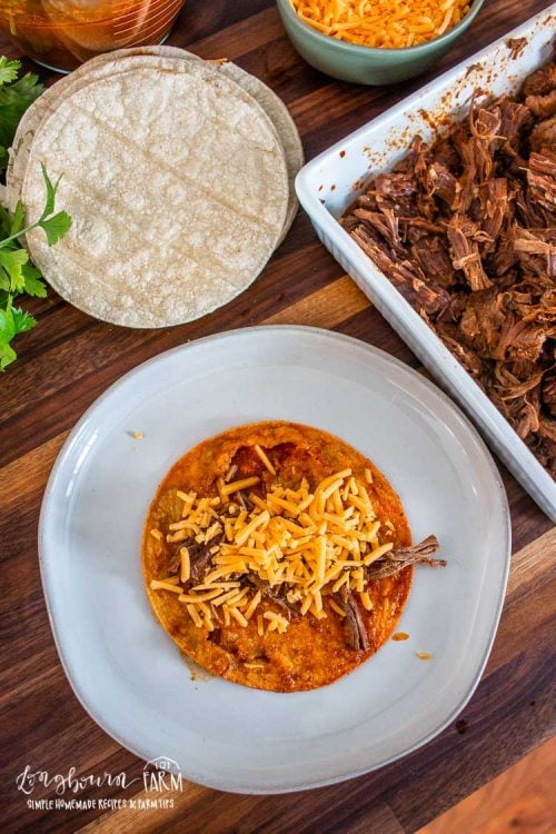 tortilla topped with shredded beef and cheese