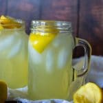 side view of chick fil a lemonade in glass mason jar and lemon to the side