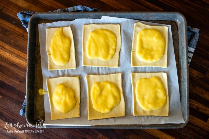 baking sheet with puff pastry squares topped with cheese sauce