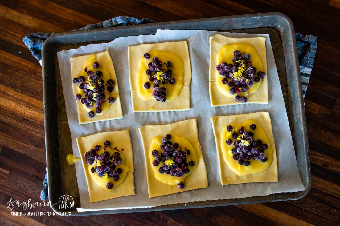 unbaked blueberry dniashes on a parchment lined baking sheet