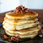 stacked maple bacon pancakes with crumbled bacon on top