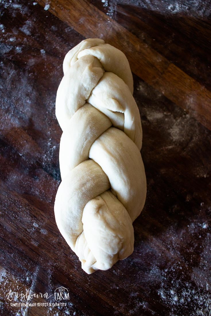 a braided bread roll on floured surface