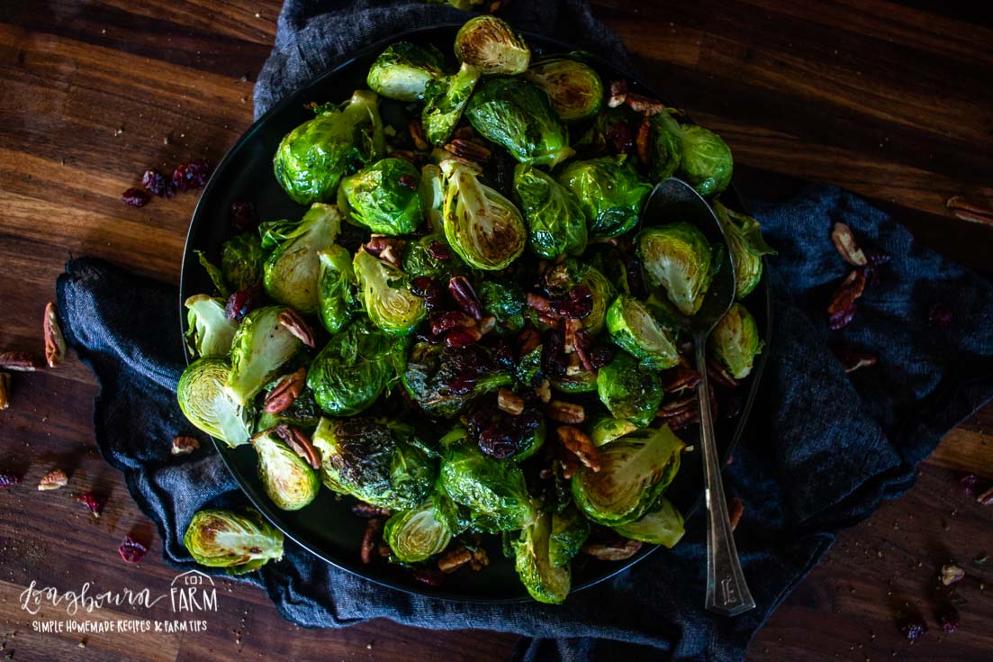 roasted brussel sprouts on a plate with a large spoon.