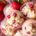 an upclose view of a stack of strawberry shortcake muffins with fresh strawberries