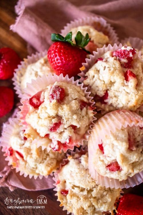 an upclose view of a stack of strawberry shortcake muffins with fresh strawberries