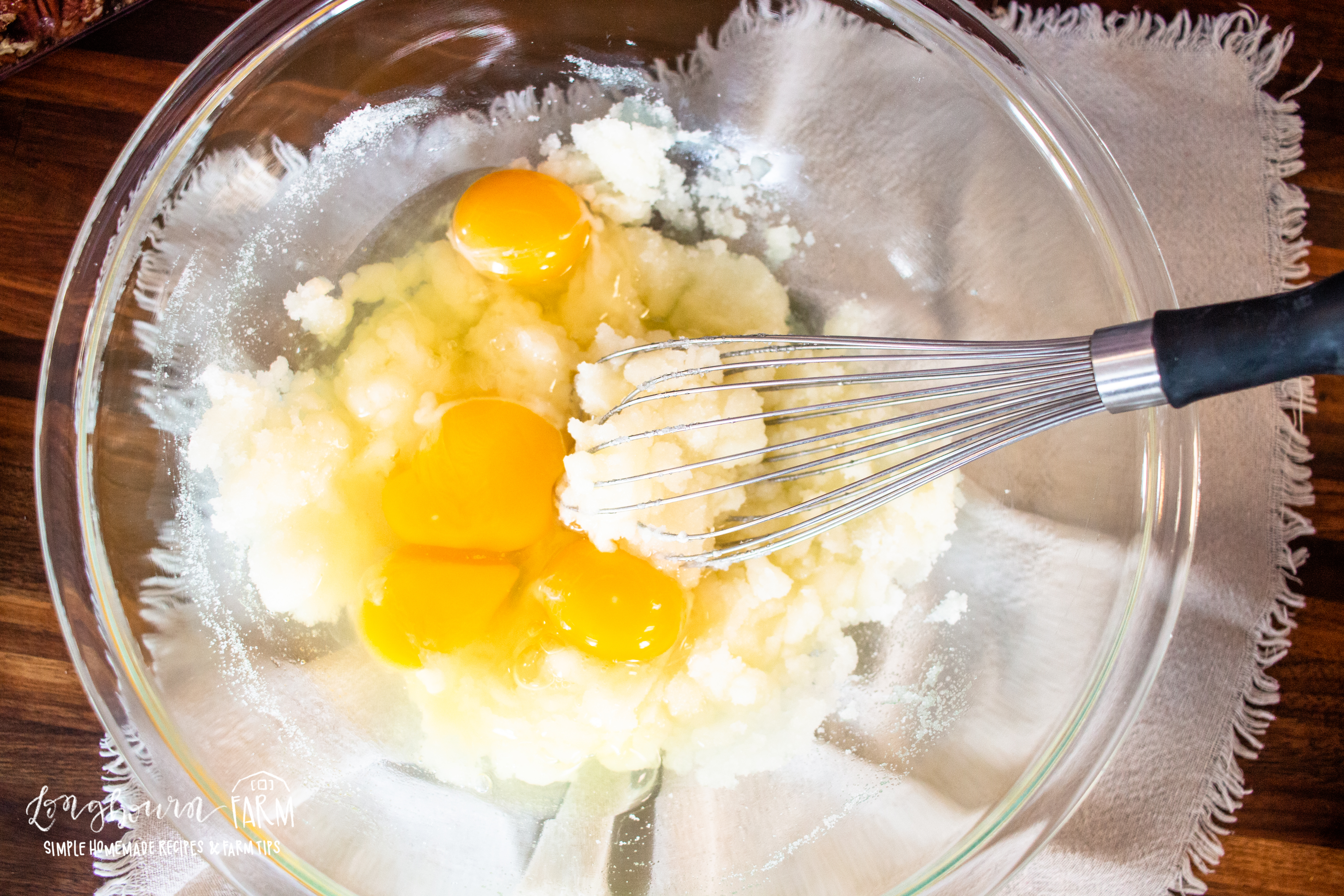 whisking eggs into a sugar mixture for muffins