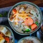 bowls of creamy cheesy ham and potato soup topped with shredded cheese