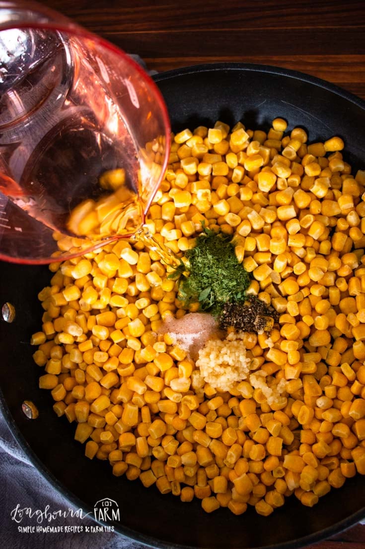 adding liquid to the pan full of corn and spices