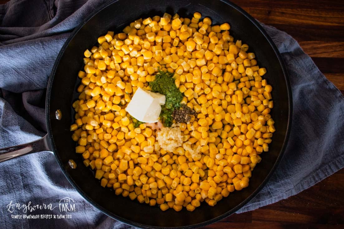 a skillet full of corn and spices with butter