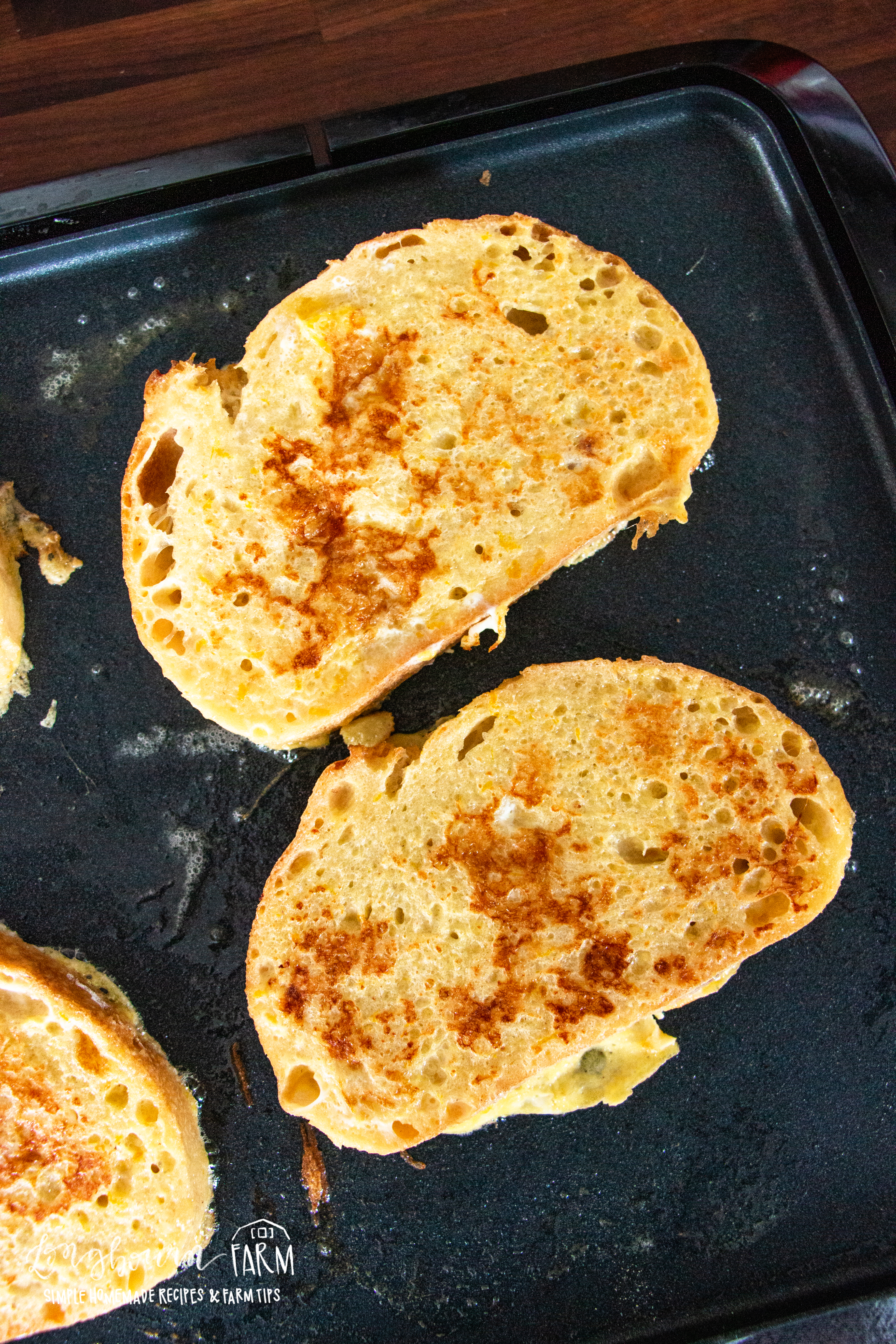 golden topped french toast pieces on an electric skillet