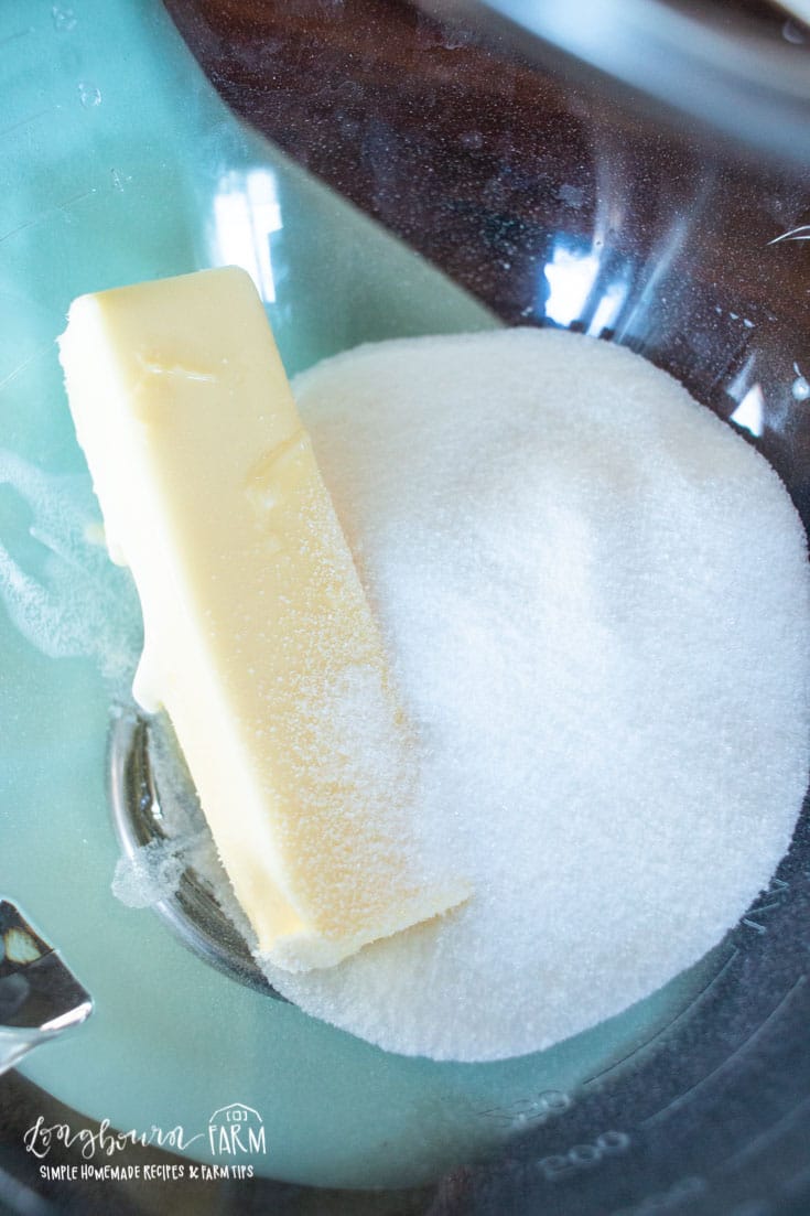 a stick of butter and sugar in the bottom of a mixing bowl