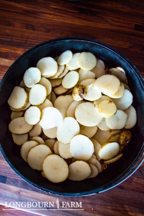 potatoes sliced into coins and placed into a dutch oven