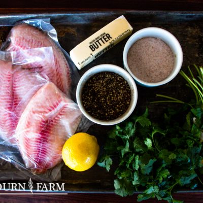 ingredients needed to make baked tilapia on a baking sheet
