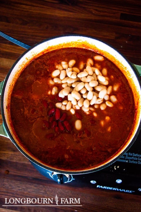 a large pot of chili with red and white beans piled in the center
