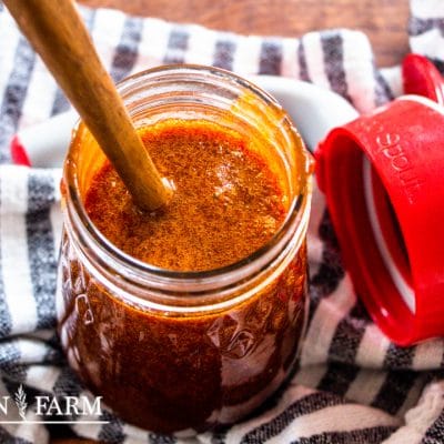 mason jar full of caramel syrup next to a syrup spout lid