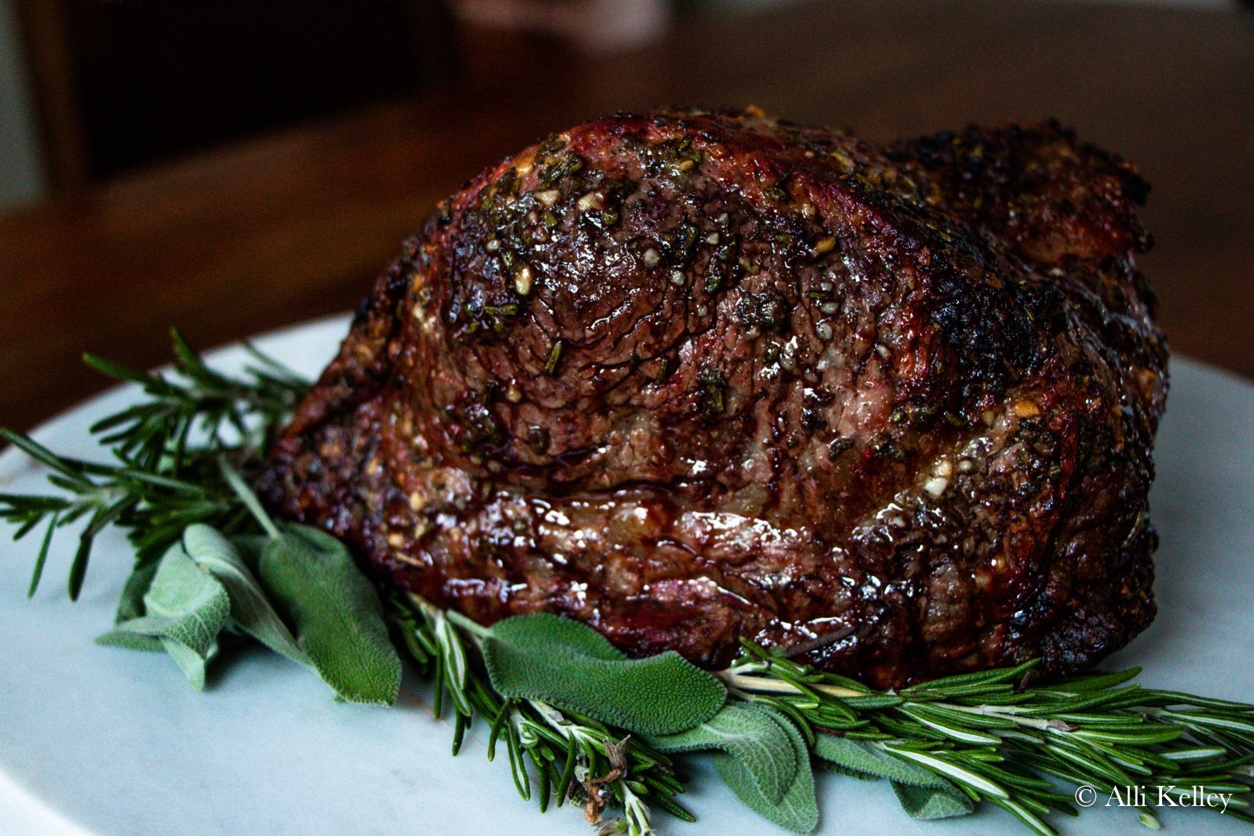 new york strip roast cooked and placed on a bed of fresh herbs