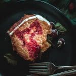 a slice of cranberry orange bundt cake drizzled with cranberry syrup on a plate