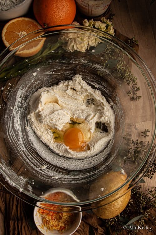 creamed butter and sugar with a cracked egg in a glass mixing bowl