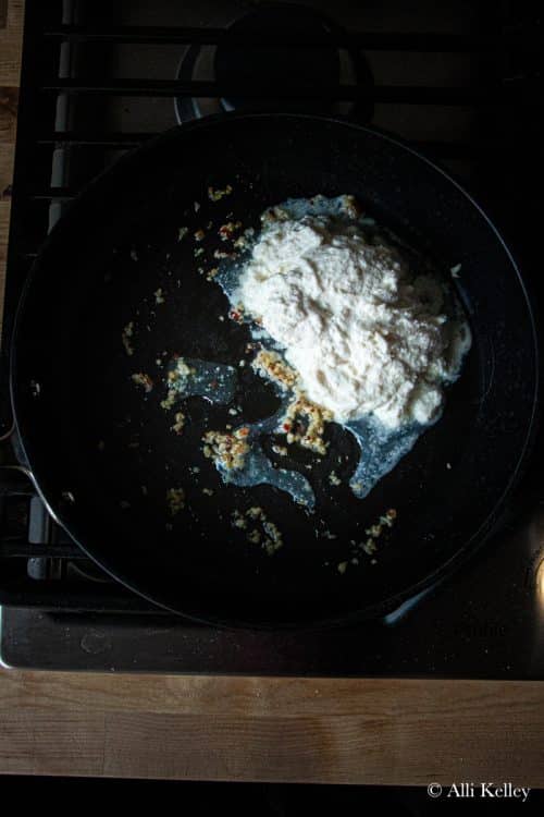 ricotta cheese with minced garlic in a skillet on the stovetop