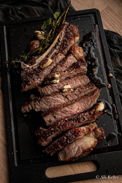 sliced cowboy steak on a chopping board