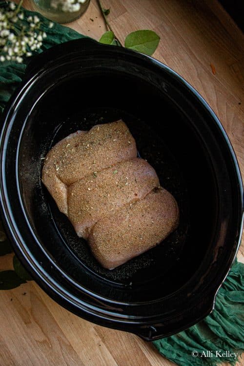 frozen chicken breast and seasonings in a slow cooker