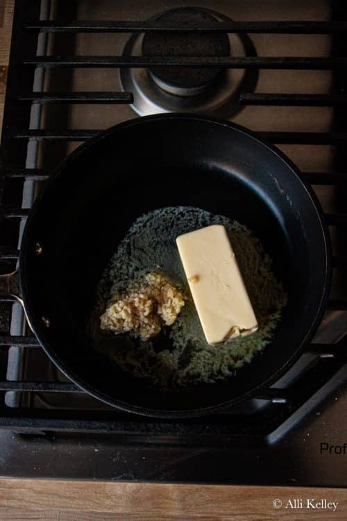 minced garlic and a stick of butter in a pan on the stove
