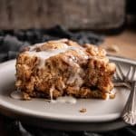 crock pot cinnamon roll casserole with icing on a plate