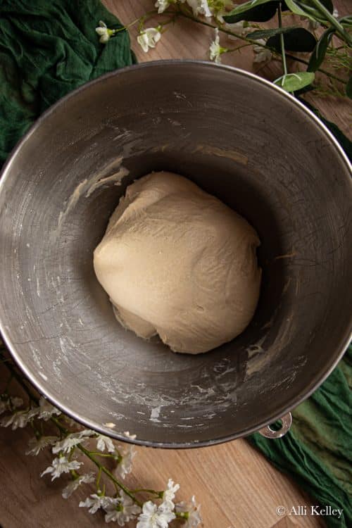 hamburger bun dough in a metal bowl
