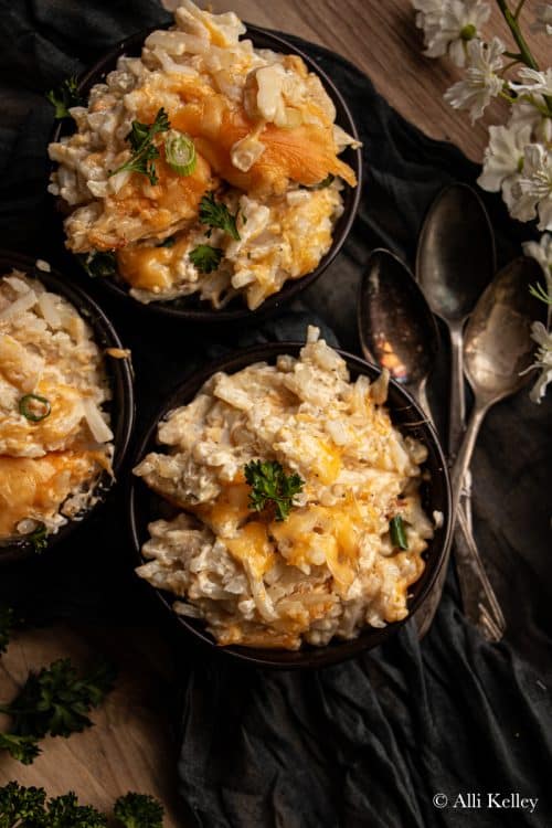 three bowls of crockpot hashbrown casserole topped with fresh herbs